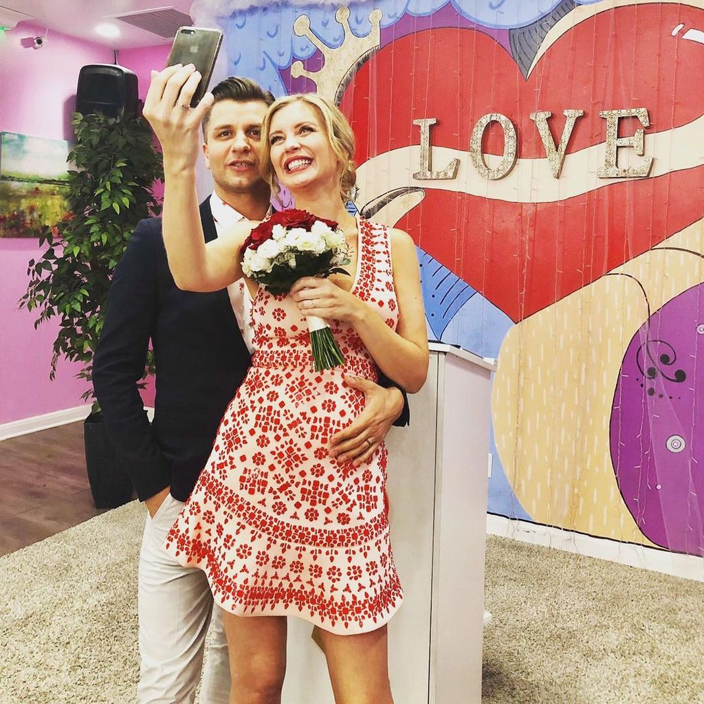 Pasha Kovalev placing his hand on Rachel Riley's baby bump on their wedding day