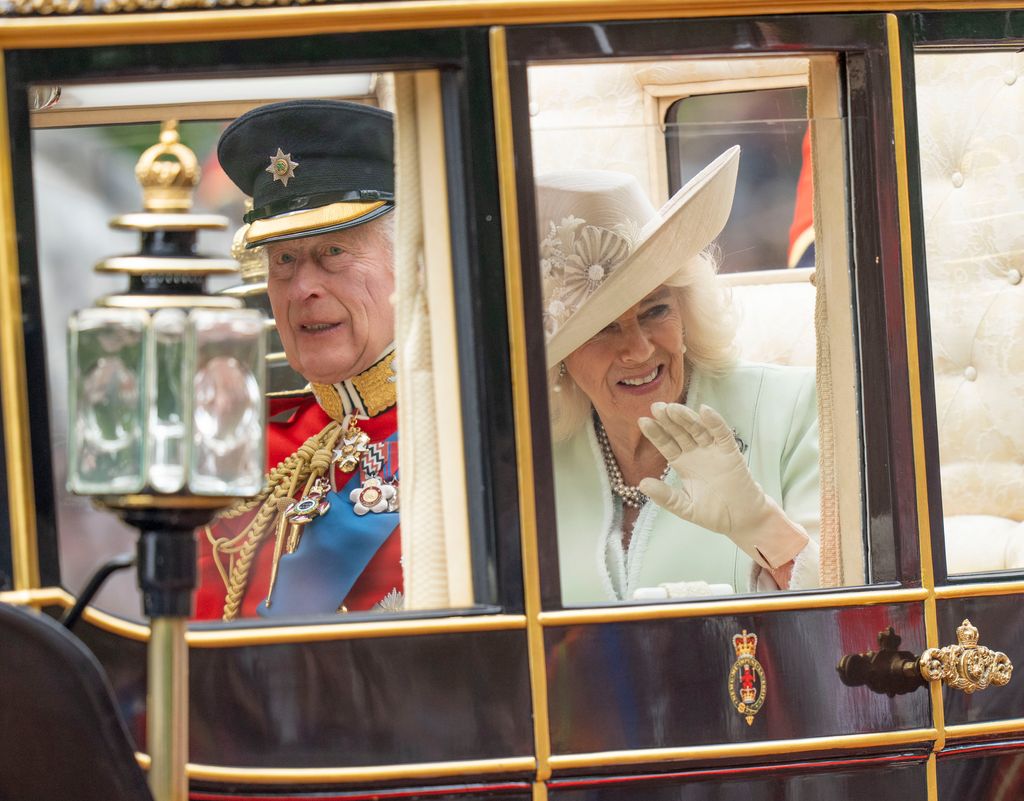 The King and Queen wave during parade