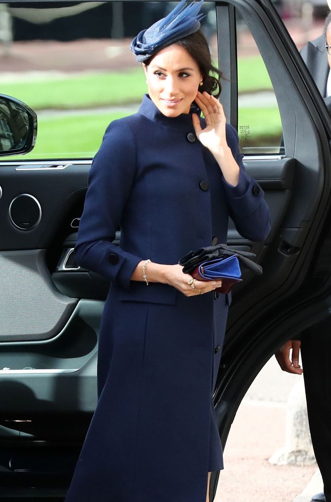 The Duchess of Sussex stepping out of the car in a blue coat wedding guest dress