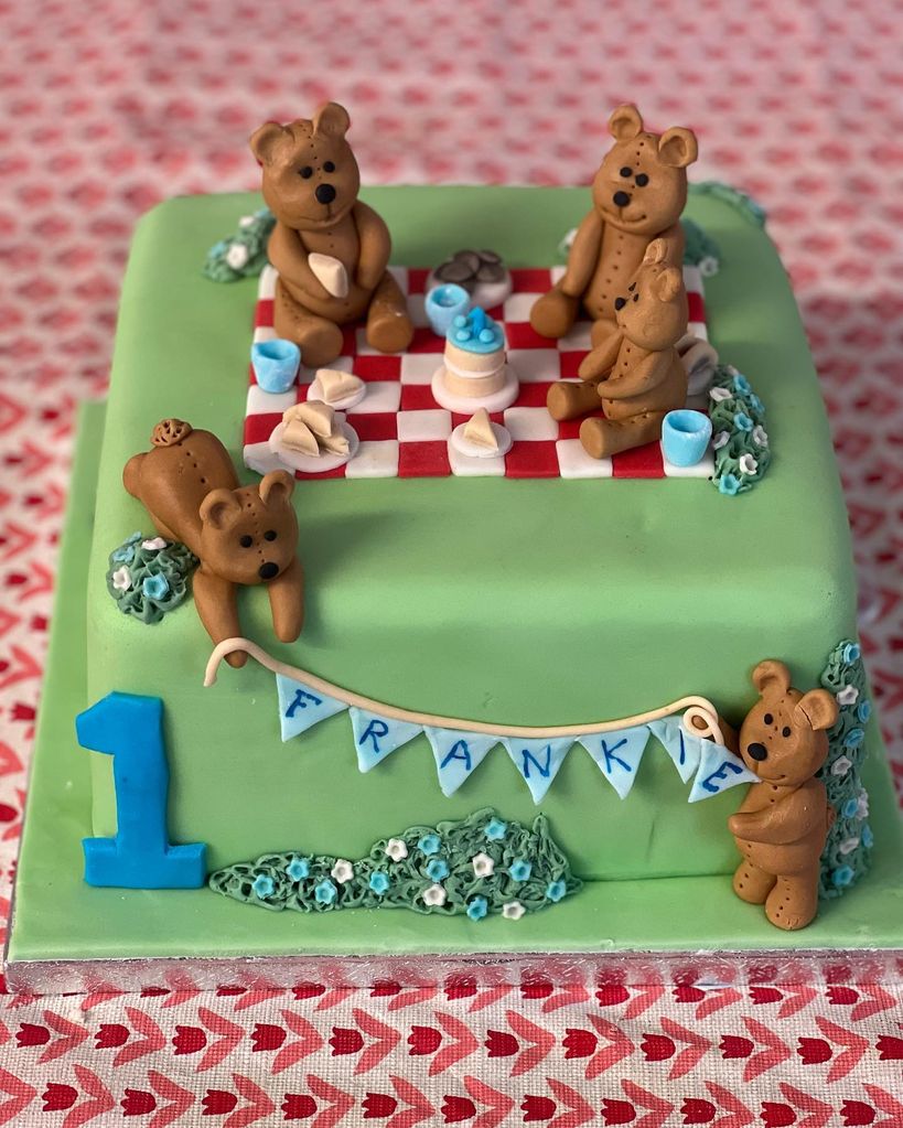 A photo of a green square birthday cake decorated with bears having a picnic 