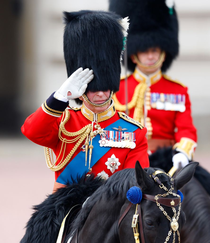 King Charles in military uniform riding a horse