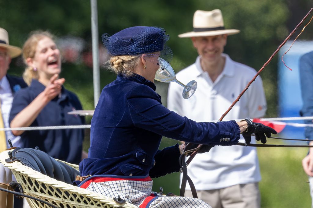 Lady Louise and Prince Edward laugh as Sophie takes part in a drinking game at a carriage driving event 