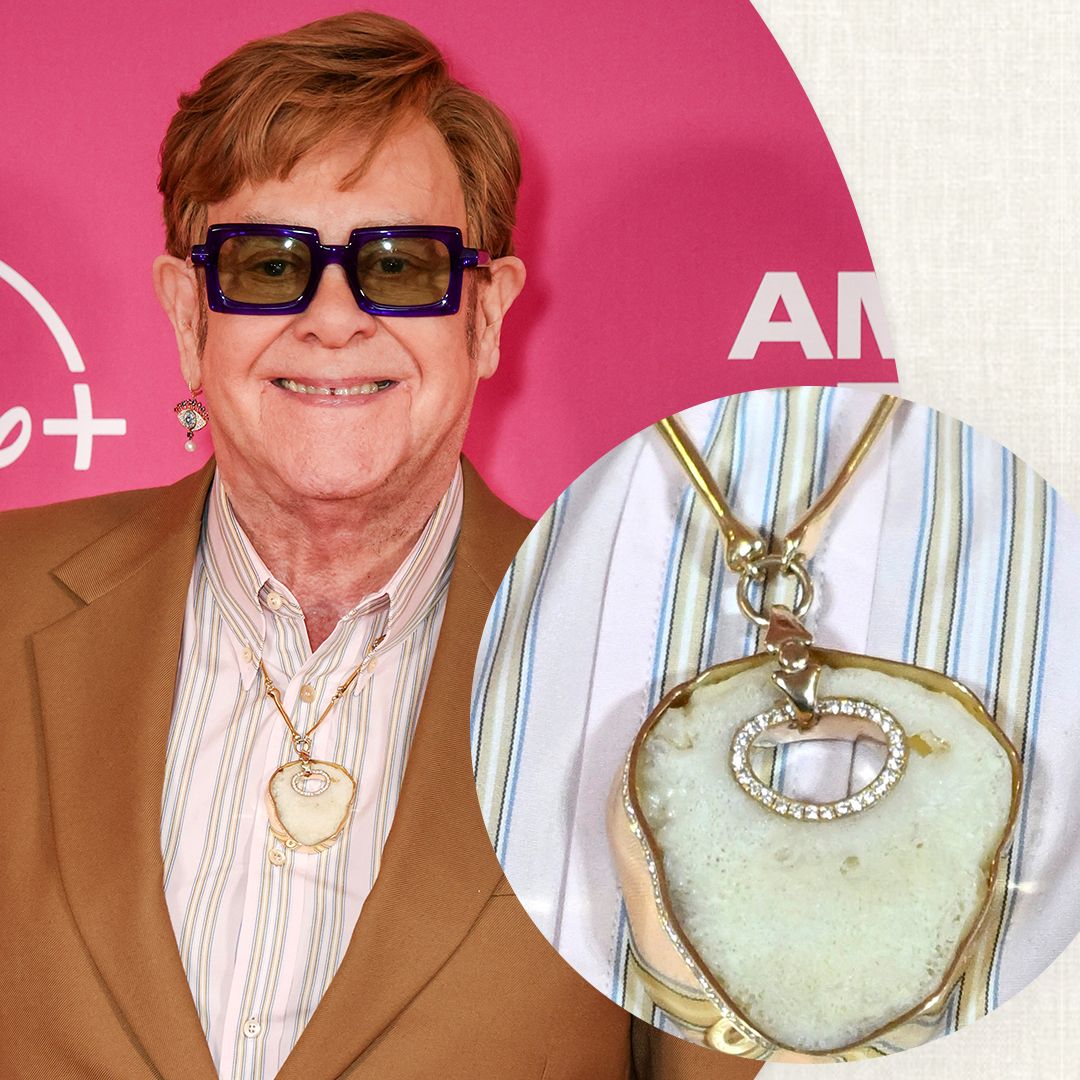 Elton John, 77, wears his own KNEECAP around his neck as he's supported by David Furnish