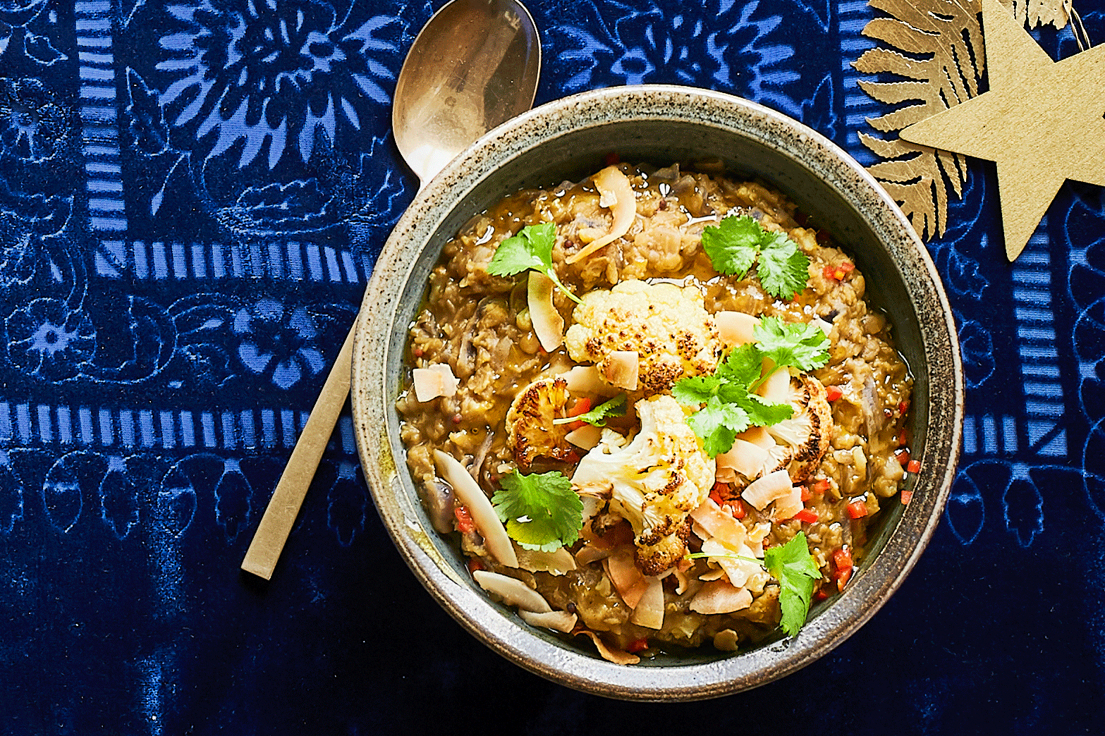 Bowl of red cabbage and cauliflower dhal on a blue background