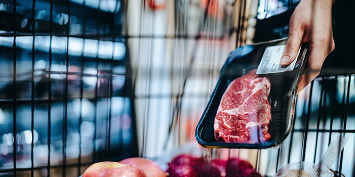 Adding meat to basket in supermarket