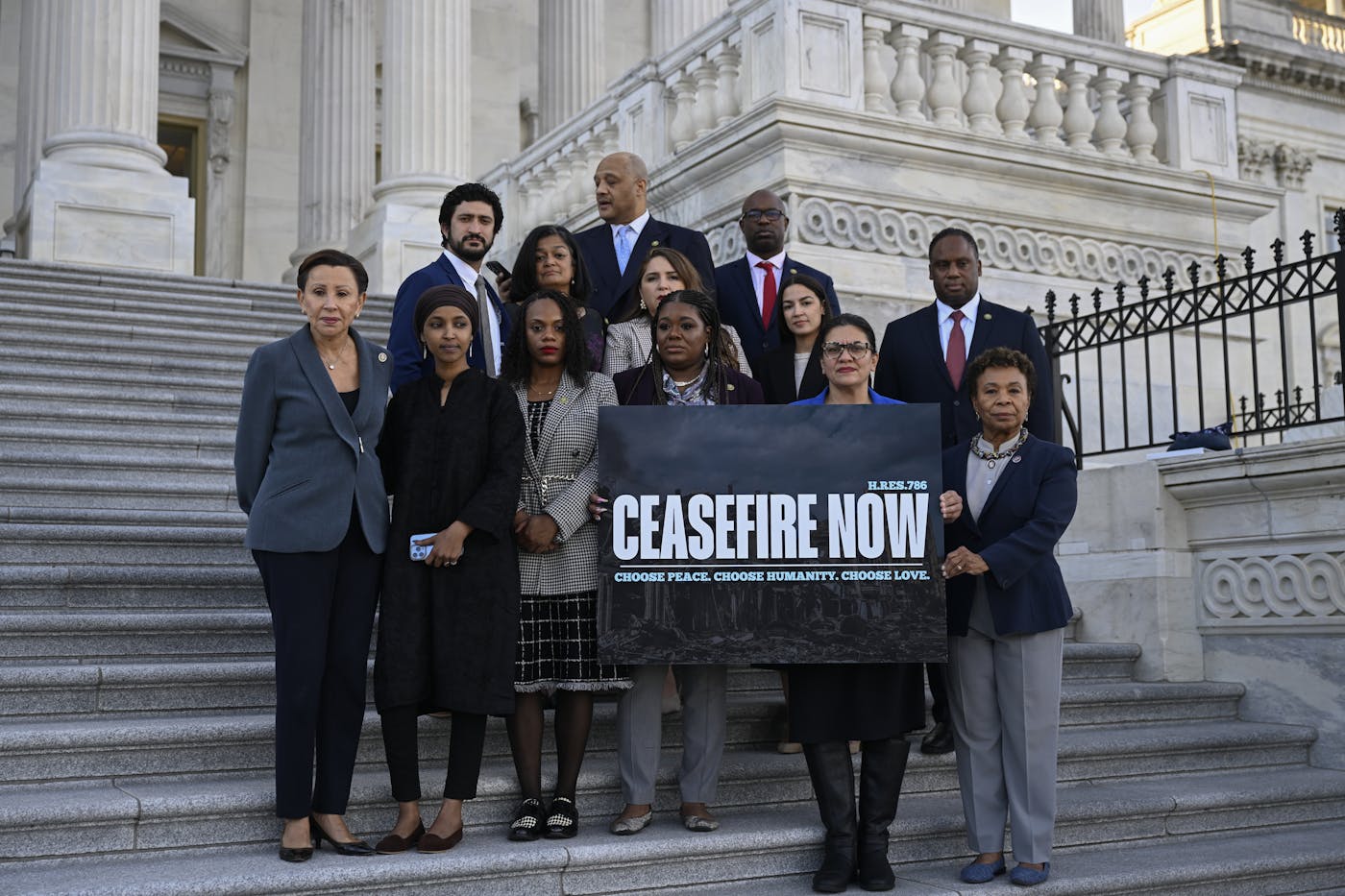 Cori Bush, Rashida Tlaib, Ilhan Omar, AOC, Barbara Lee, and seven other representatives hold a banner calling for a ceasefire on the Capitol steps.