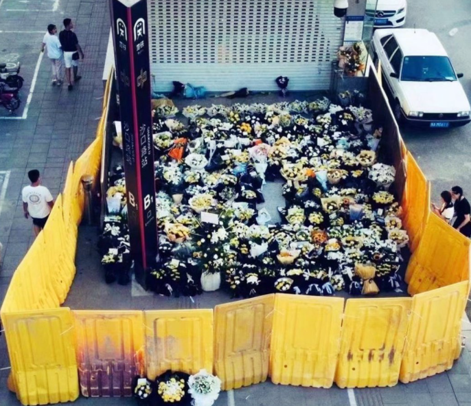 一些民眾自發在地鐵站沙口路站出口獻花悼念，但獻花區周邊卻被與人同高的圍欄擋住。   圖：翻攝微博