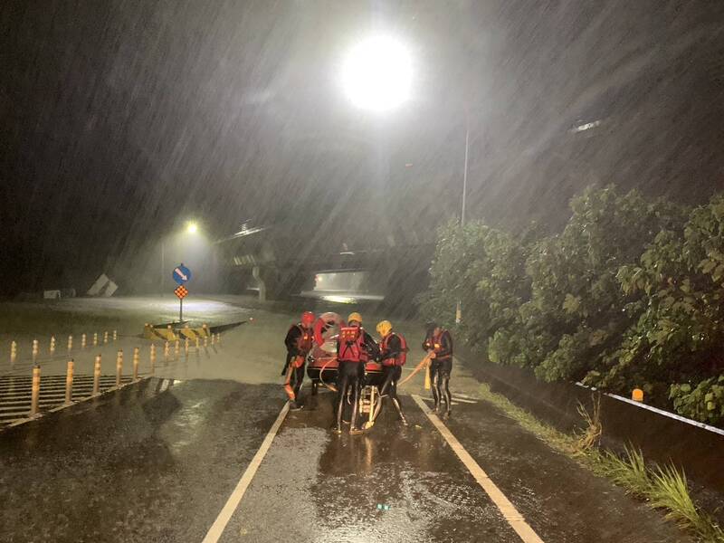 凱米颱風為嘉義縣帶來大雨，八掌溪水暴漲溢堤，民眾受困於台82線中和交流道，嘉義縣消防局25日清晨派員協助脫困。   圖：中央社/嘉義縣消防局提供