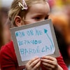 Une enfant tient une affiche sur laquelle est écrit : «On ne veut pas de Bardella».