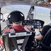 Deux pilotes dans un hélicoptère survolent la forêt. 