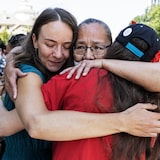 Three women are hugging.