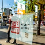 "Help wanted" sign in the window of a store.