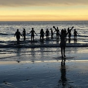 Des gens se baignent durant l'éclipse, semblable à un coucher de soleil.