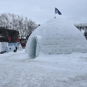 Un gros igloo avec un drapeau à son sommet. 