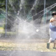 Un enfant joue dans un parc de jeux d'eau.