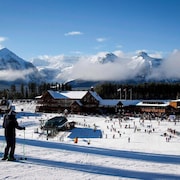 Le bas de la station de ski de Lake Louise avec des centaines de skieurs. Il y a des montagnes en arrière.