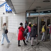 Des gens franchissent l'entrée de la station Frontenac du métro de Montréal.