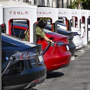 Des bornes de recharge Tesla et des voitures qui y sont branchées.