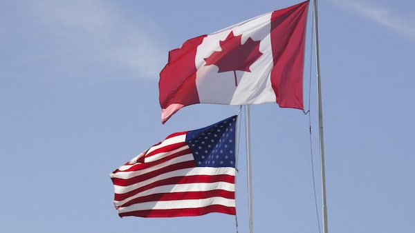 Les drapeaux du Canada et des États-Unis flottent au parc de l'Arche de la paix, situé à la frontière entre les deux pays à proximité de Surrey, en Colombie-Britannique.