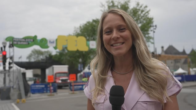 Une jeune femme sourit devant le logo du FEQ. 