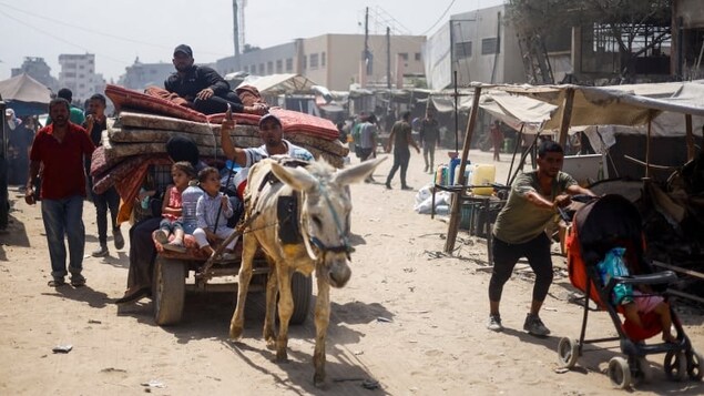 Palestinians who fled the eastern part of Khan Younis, in the southern Gaza Strip, after they were ordered by Israeli army to evacuate ride on an animal-drawn cart loaded with belongings, on Tuesday. 