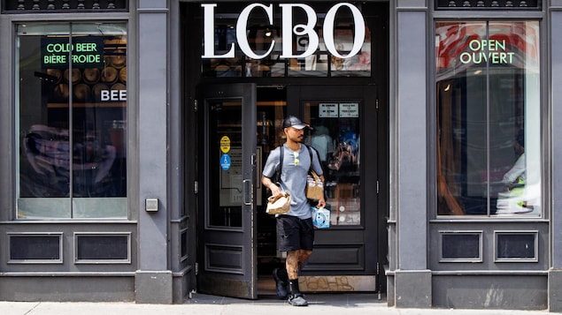 Un client sort d'une succursale de la LCBO avec ses achats.