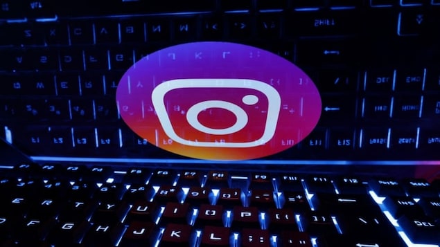 A keyboard is placed in front of a displayed Instagram logo in an illustration shown in 2023. Beginning Tuesday in Canada and other countries, anyone under under 18 who signs up for Instagram will be placed into a teen account and pre-existing accounts of minors will soon migrate over to that category. 