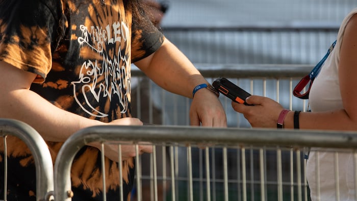 Un festivalier fait valider son bracelet à l'entrée du site. 