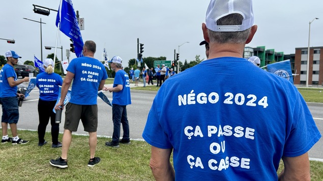 Un gréviste porte un chandail où il est inscrit : « Négo 2024, ça passe ou ça casse ».