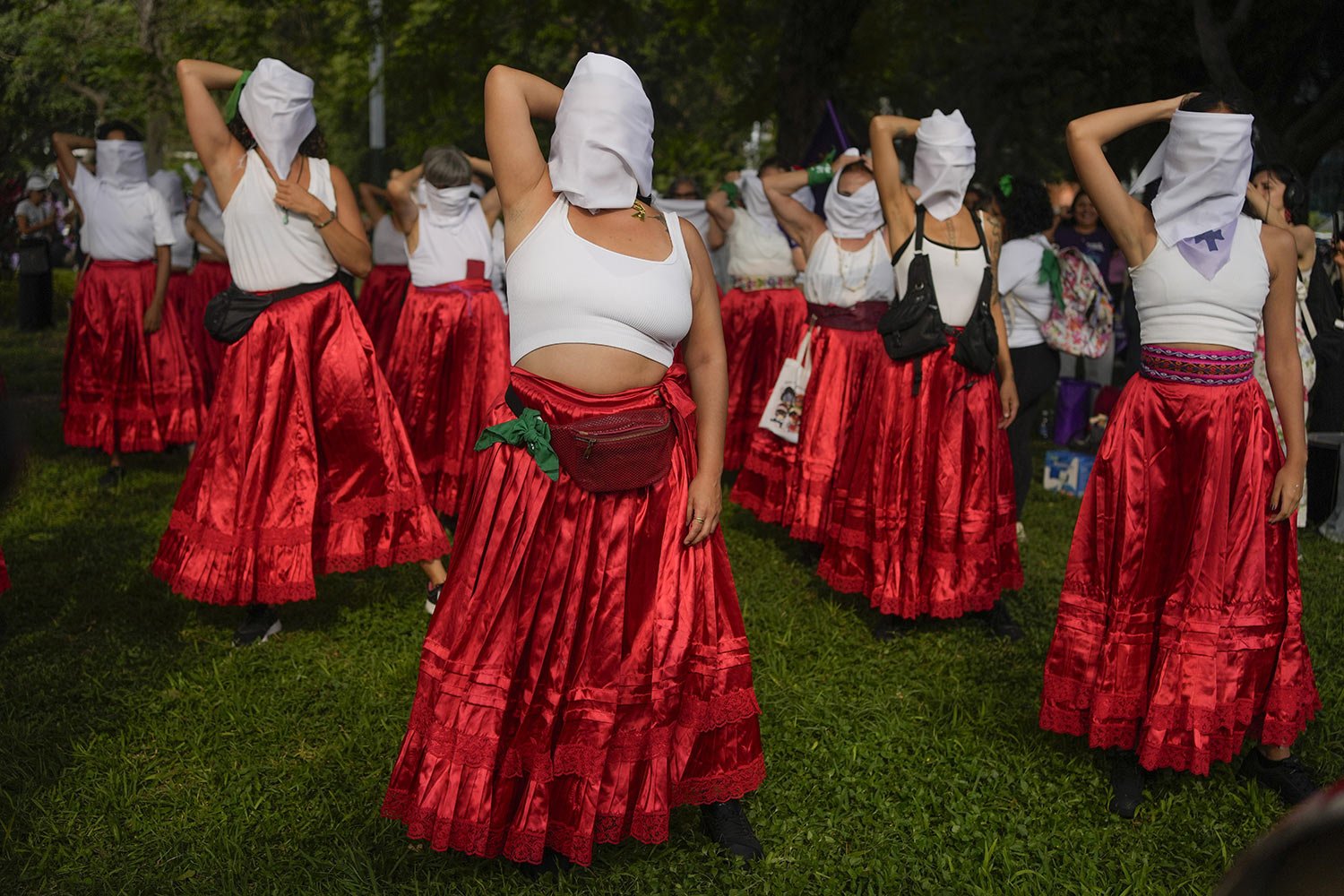  Women cover their faces with white scarves to symbolize that they are invisible in the justice system during a performance on International Women's Day in Lima, Peru, March 8, 2024. (AP Photo/Martin Mejia) 