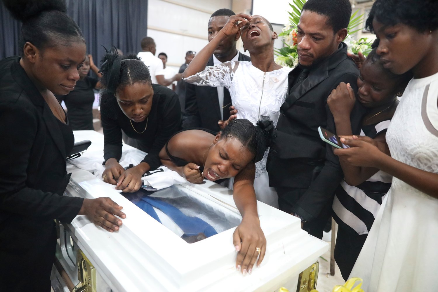  Relatives mourn over the coffin of murder victim Saintus Leodens during his funeral service in Port-au-Prince, Haiti, May 25, 2024. (AP Photo/Odelyn Joseph) 