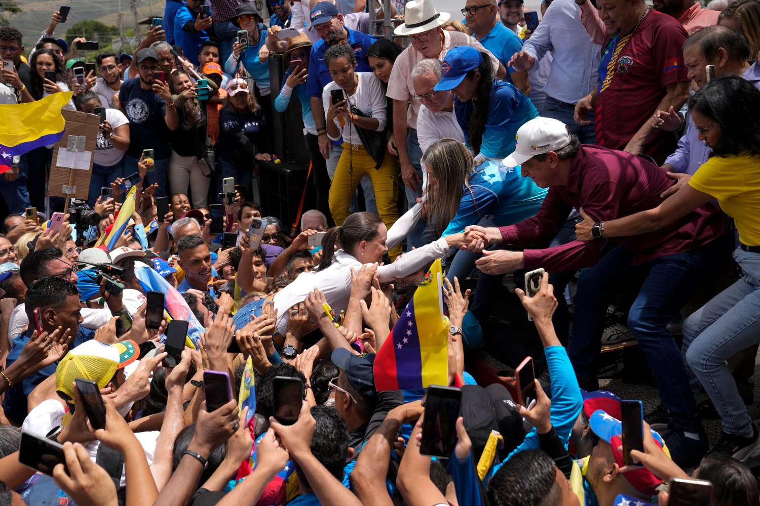  Opposition leader Maria Corina Machado is lifted onto the stage as she arrives to help launch the campaign for the opposition’s presidential candidate Edmundo González Urrutia in La Victoria, Venezuela, May 18, 2024. (AP Photo/Ariana Cubillos) 