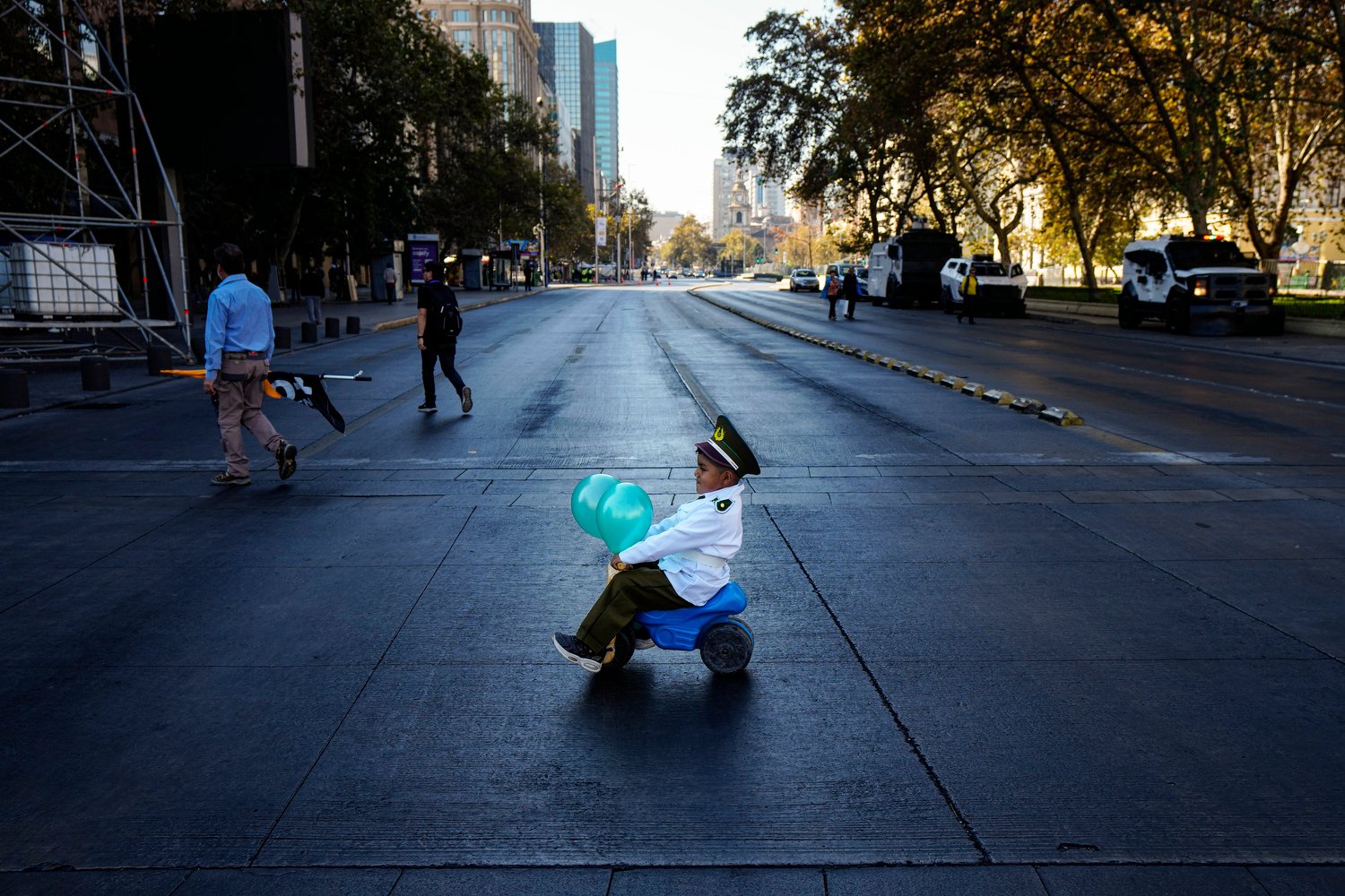  A child dressed as a police officer steers his toy behind his parents to a demonstration seeking justice for police killed in the line of duty in Santiago, Chile, April 27, 2024. (AP Photo/Esteban Felix) 