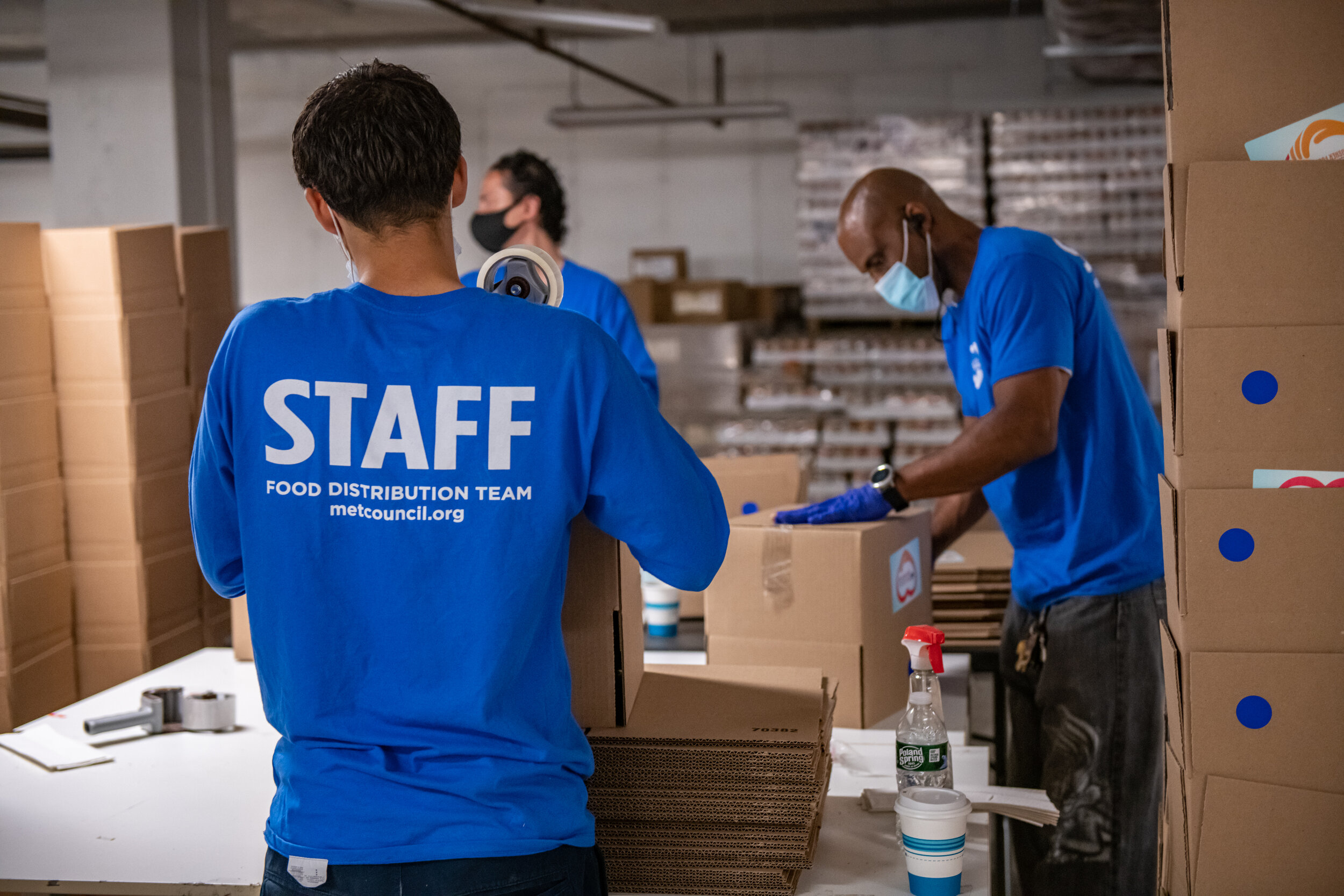 3 volunteers assembling boxes together in Met Council's Greenpoint fulfillment center