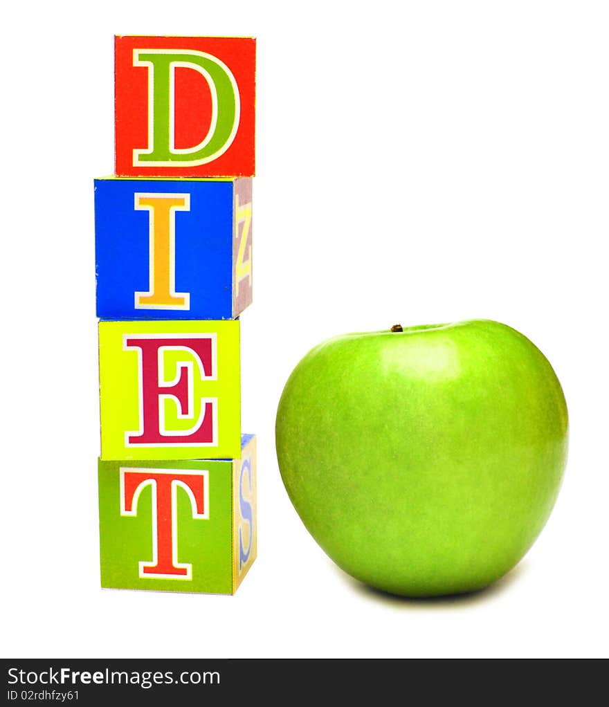 Green apple and cubes with letters in front of a white background - diet. Green apple and cubes with letters in front of a white background - diet