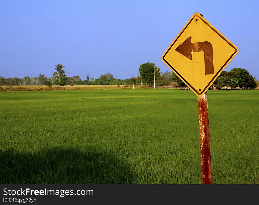 Turn left sign to rice feild