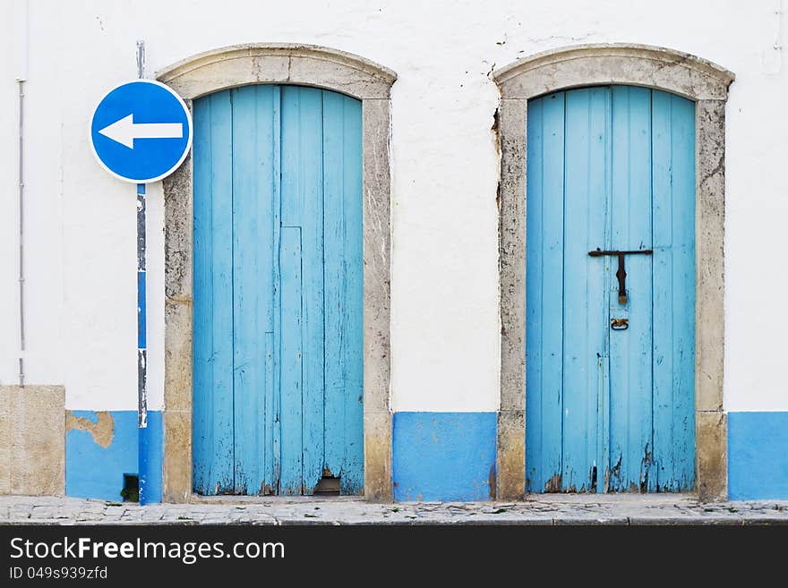 Two blue doors and blue traffic sign