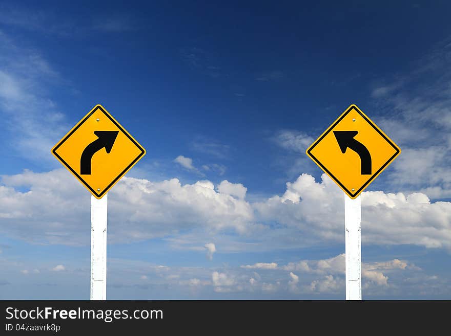 Left and right turn warning sign with blue sky