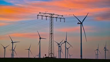 Hochspannungsmast in einem Windpark.