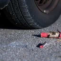 Die Reste von Böllern liegen auf der Straße neben einem Auto.