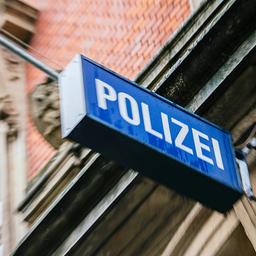 An einer Hausfassade hängt ein Leuchtschild mit der Aufschrift Polizei.