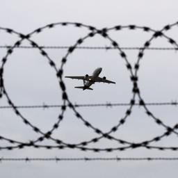 Ein Passagierflugzeug startet hinter einer Stacheldrahtabsperrung.