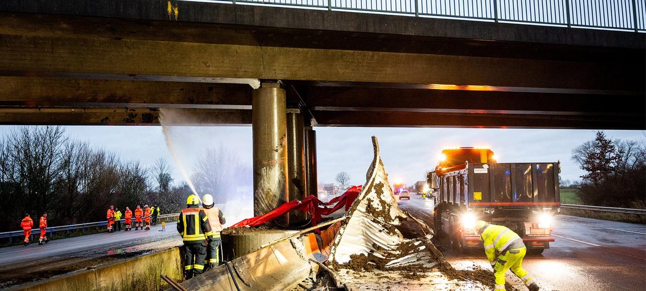 Stapelfeld: Einsatzkräfte stehen auf der Autobahn 1 nach einem Unfall an einer Brücke.