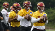 Jun 5, 2024; Ashburn, VA, USA; Washington Commanders quarterback Jeff Driskel (16), Commanders quarterback Marcus Mariota (0), and Commanders quarterback Jayden Daniels (5) prepare to pass a ball during OTA workouts at Commanders Park.