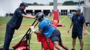 Offensive lineman John Ojukwu (61) hits the sled with offensive line coach Bill Callahan, right, watching during the Tennessee Titans mandatory mini-camp at Ascension Saint Thomas Sports Park in Nashville, Tenn., Wednesday, June 5, 2024.