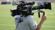 A HBO Hard Knocks cameraman films video footage. 