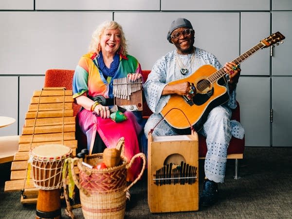 a woman and a man surrounded by several instruments