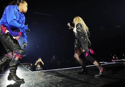 Two people sing and dance together onstage