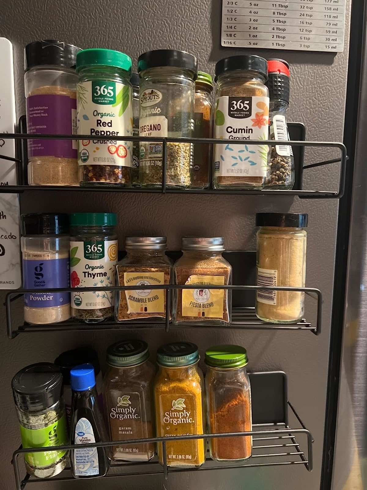 Reviewer&#x27;s three racks on side of fridge storing spices