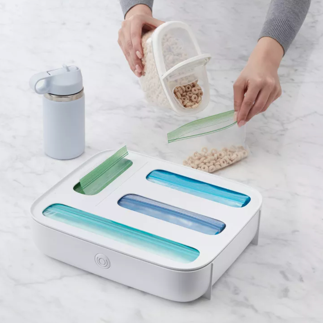 a food bag organizer and a person pouring cheerios into a snack bag next to it